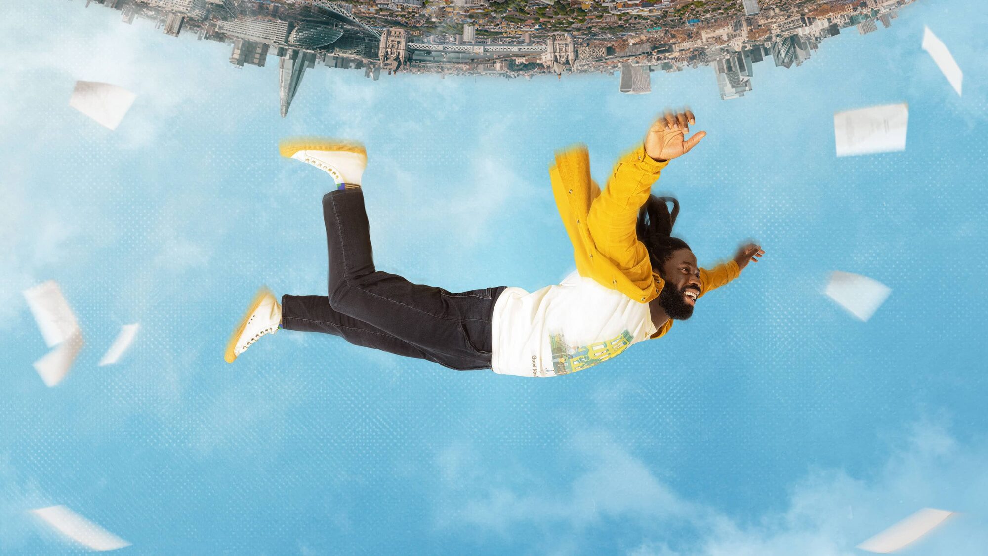 Man in gele jas en wit shirt valt door de blauwe lucht met papieren om zich een vliegend en een stad op de achtergrond