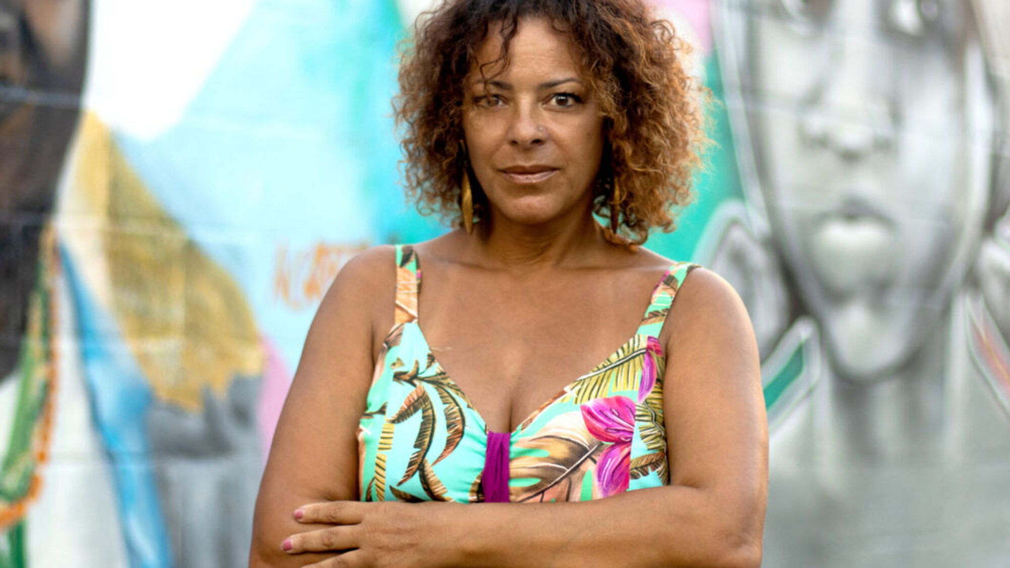 Nina Jurna staat voor een muurschildering met een vrolijke top aan