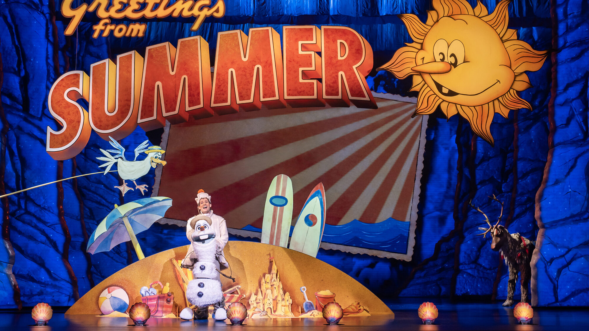 Je ziet een acteur in een sneeuwpop-pak voor een decor met ...