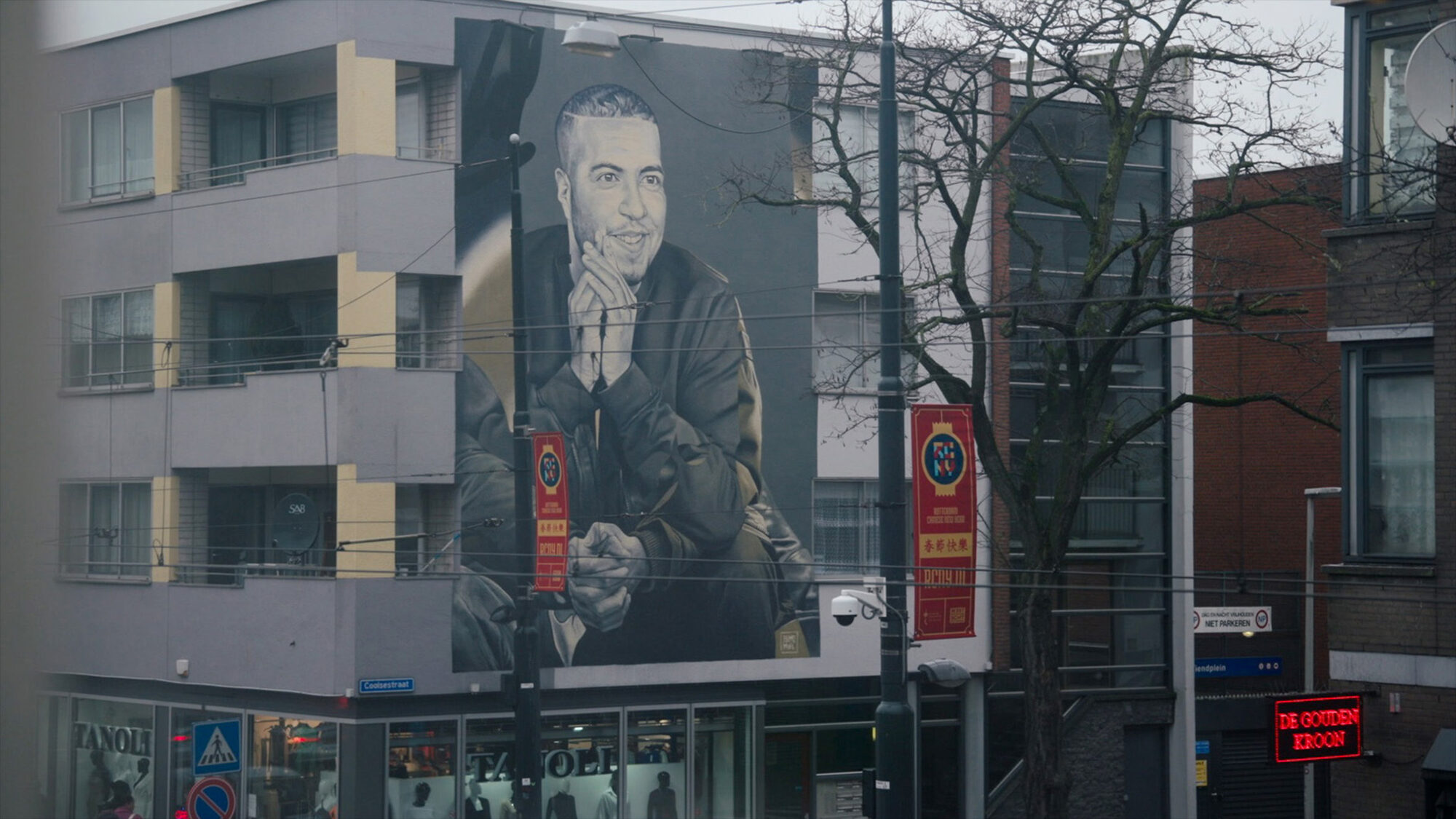 Muurschildering van rapper Feis op de zijkant van een pand in Rotterdam.