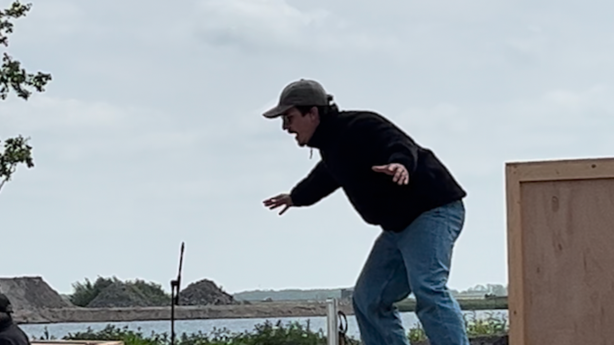 Stil uit een scene van het stuk. Acteur Jurriaan staat op een houtenblok op de zandafgraving in Nij Beets.