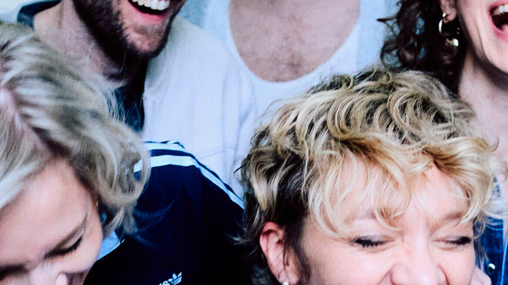 Foto van de band Krezip. Een chaotische foto, van lachende mensen in de lift, van heel dichtbij genomen.