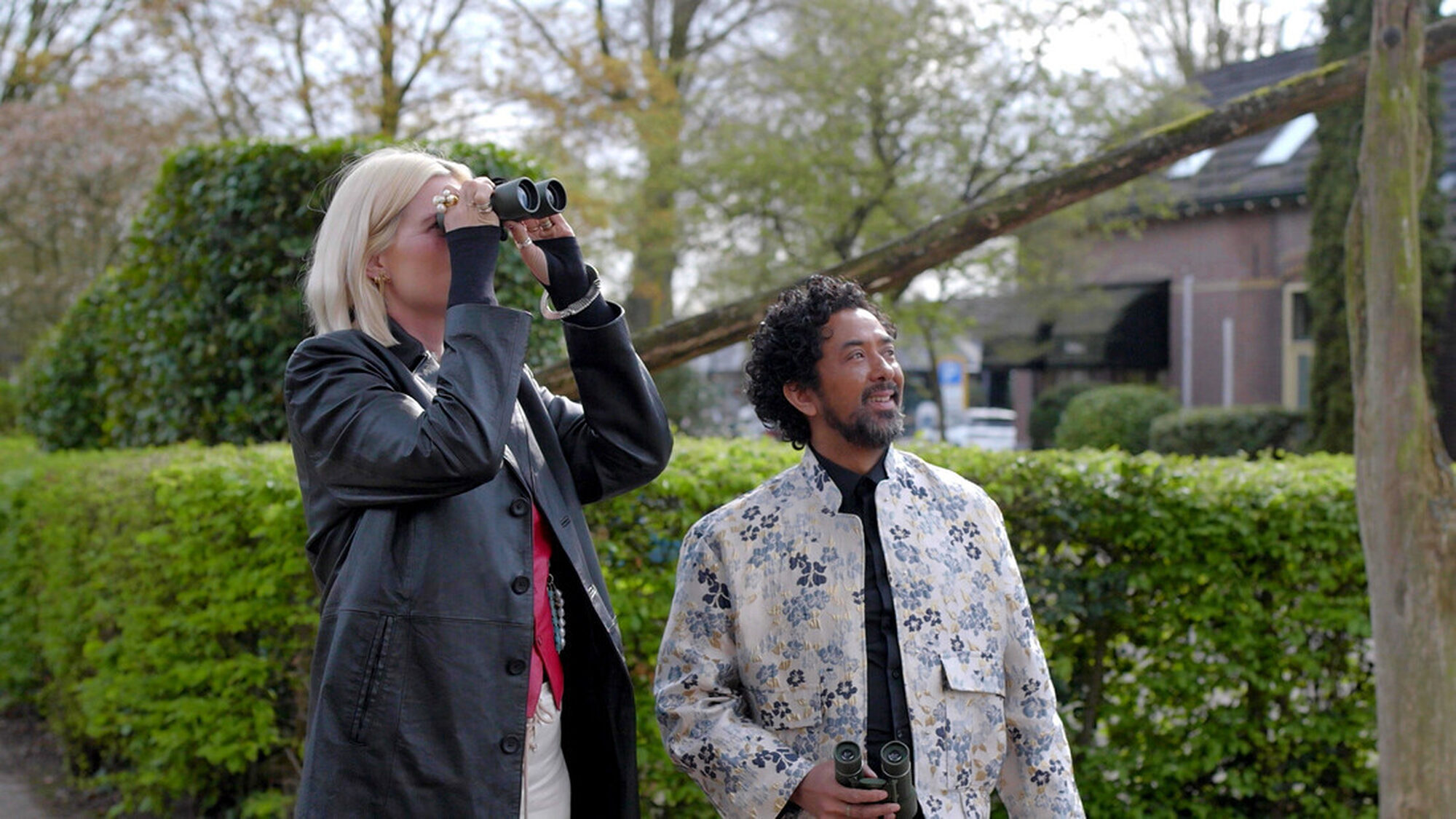 Man en vrouw staan samen buiten met een verrekijker te kijken naar iets in de verte
