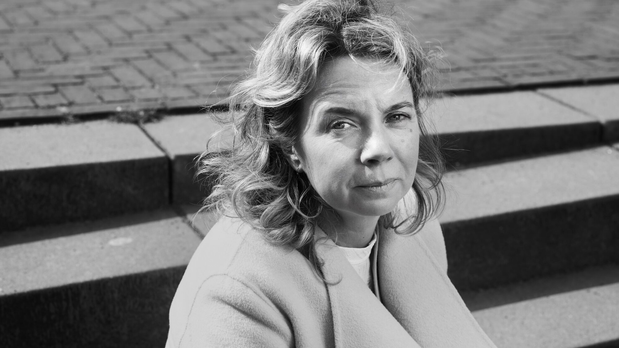 Een van de geportretteerden door Robin de Puy. Zwartwit foto waarin een vrouw in de camera kijkt.