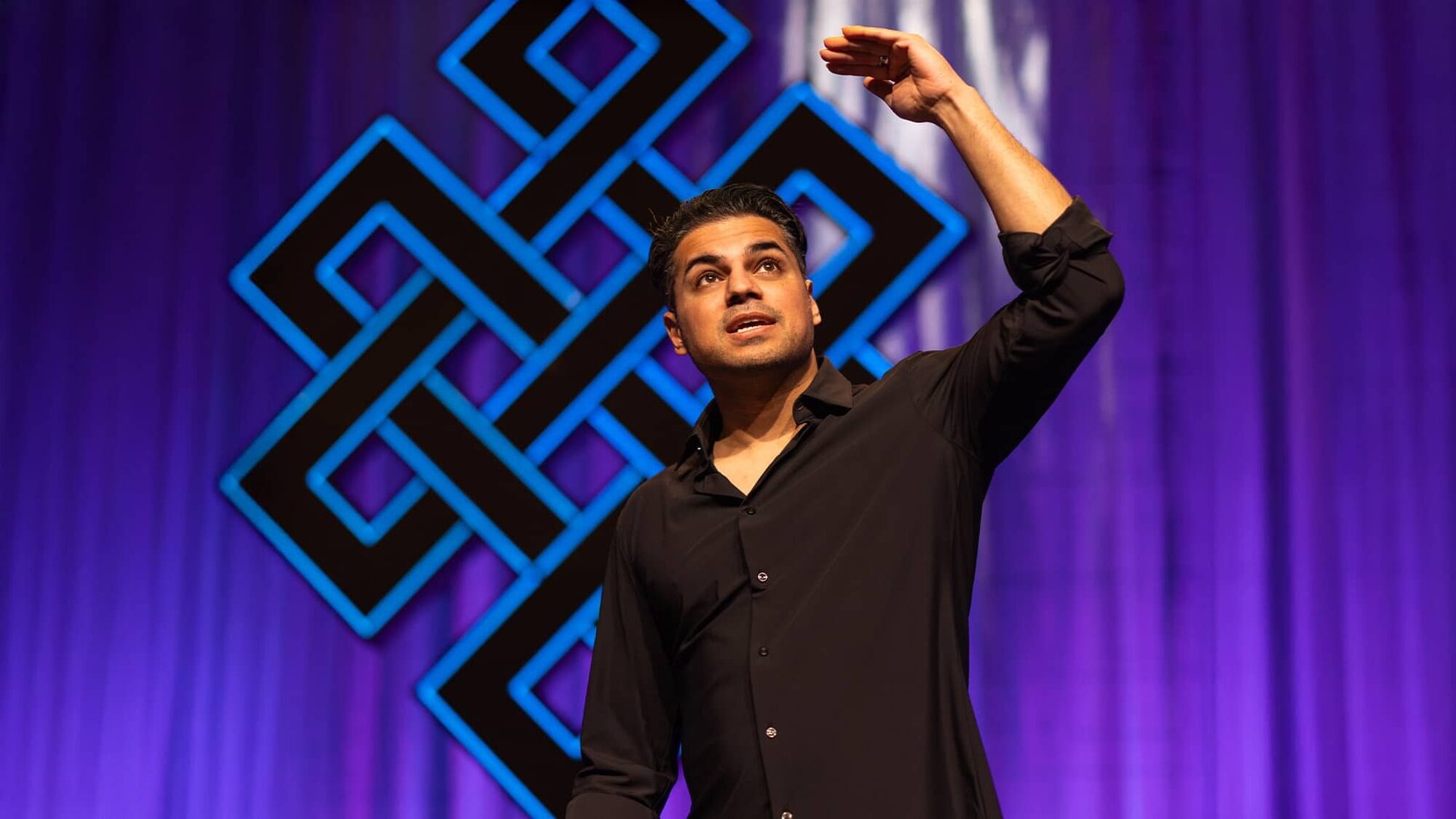 Cabaretier op het podium in actie voor een karma-teken