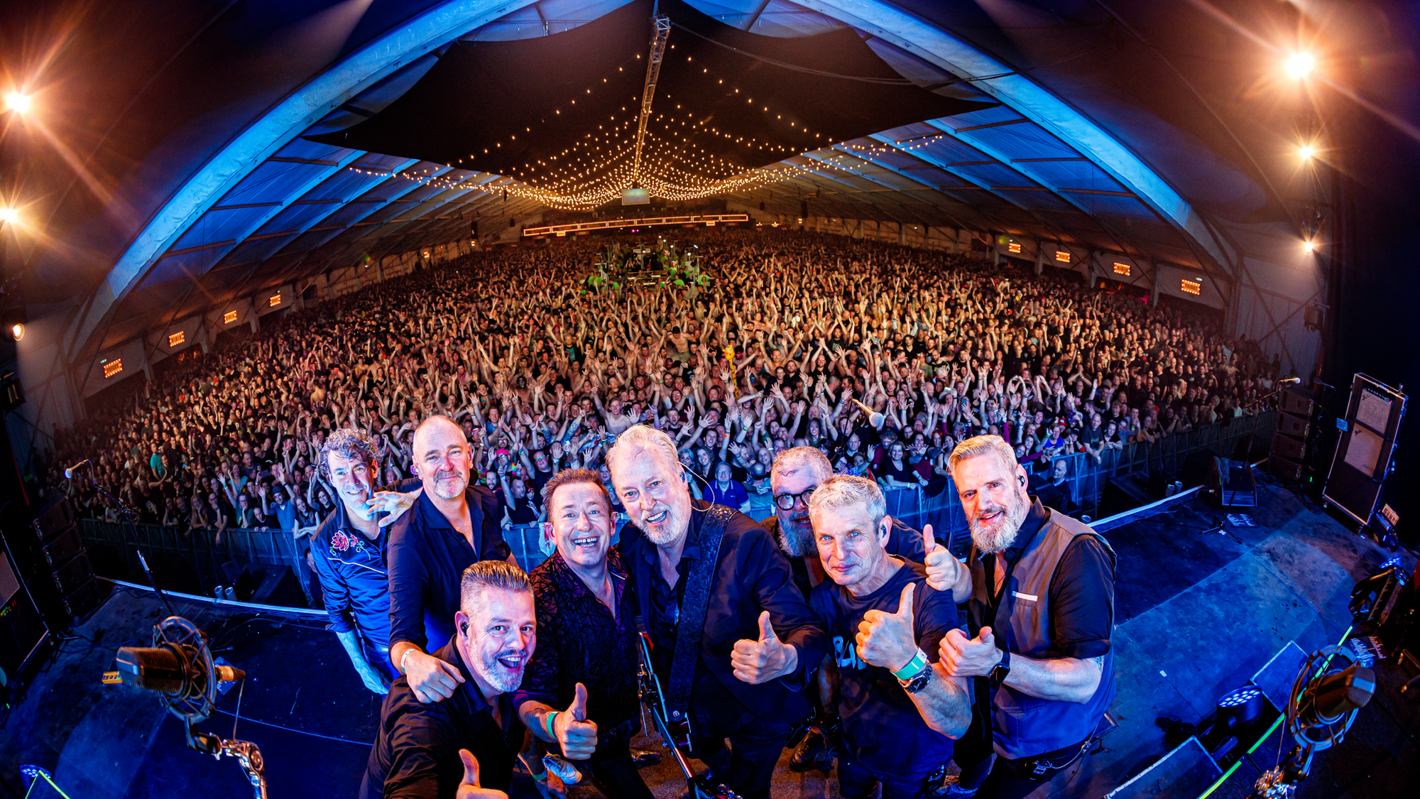 Rowwen Hèze op de foto tijdens een optreden met het publiek op de achtergrond