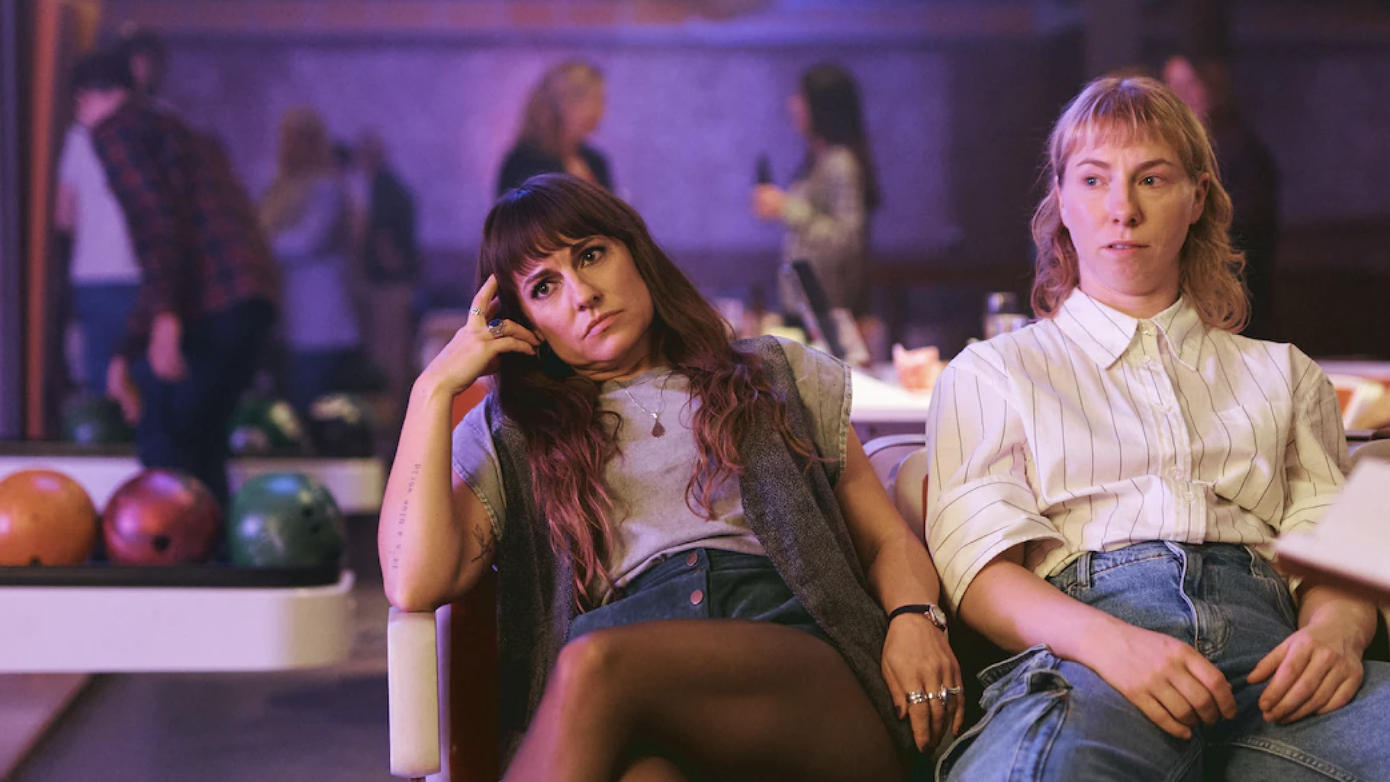 Twee zussen zitten verveeld bij een bowlingbaan