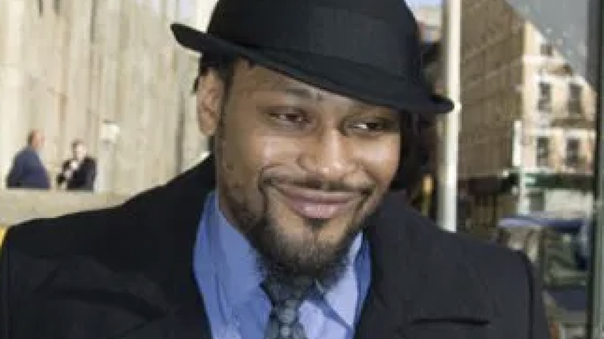 D'Angelo met een hoed op en pak aan op straat