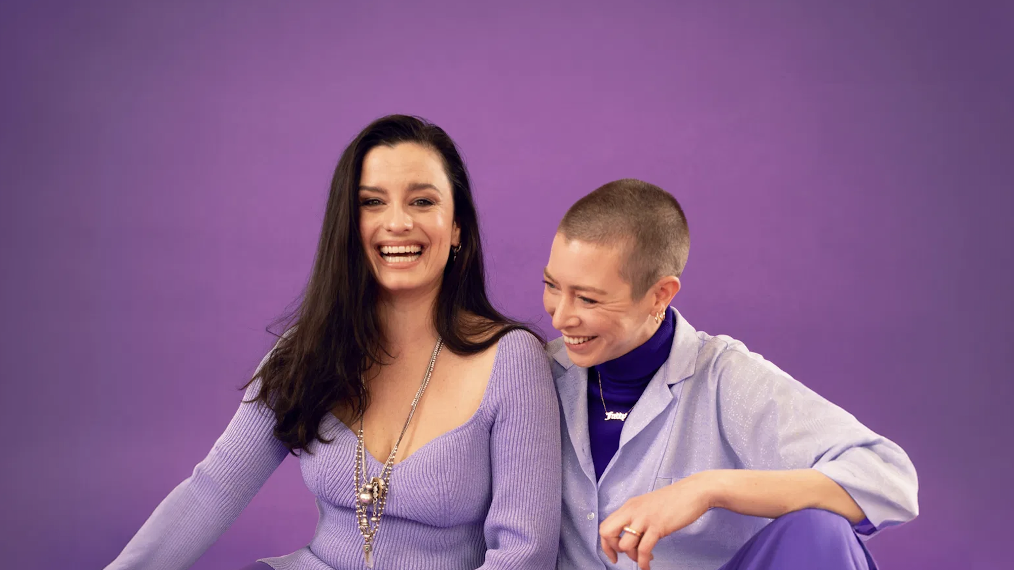 Presentatoren van Een uur cultuur poseren voor een paarse achtergrond