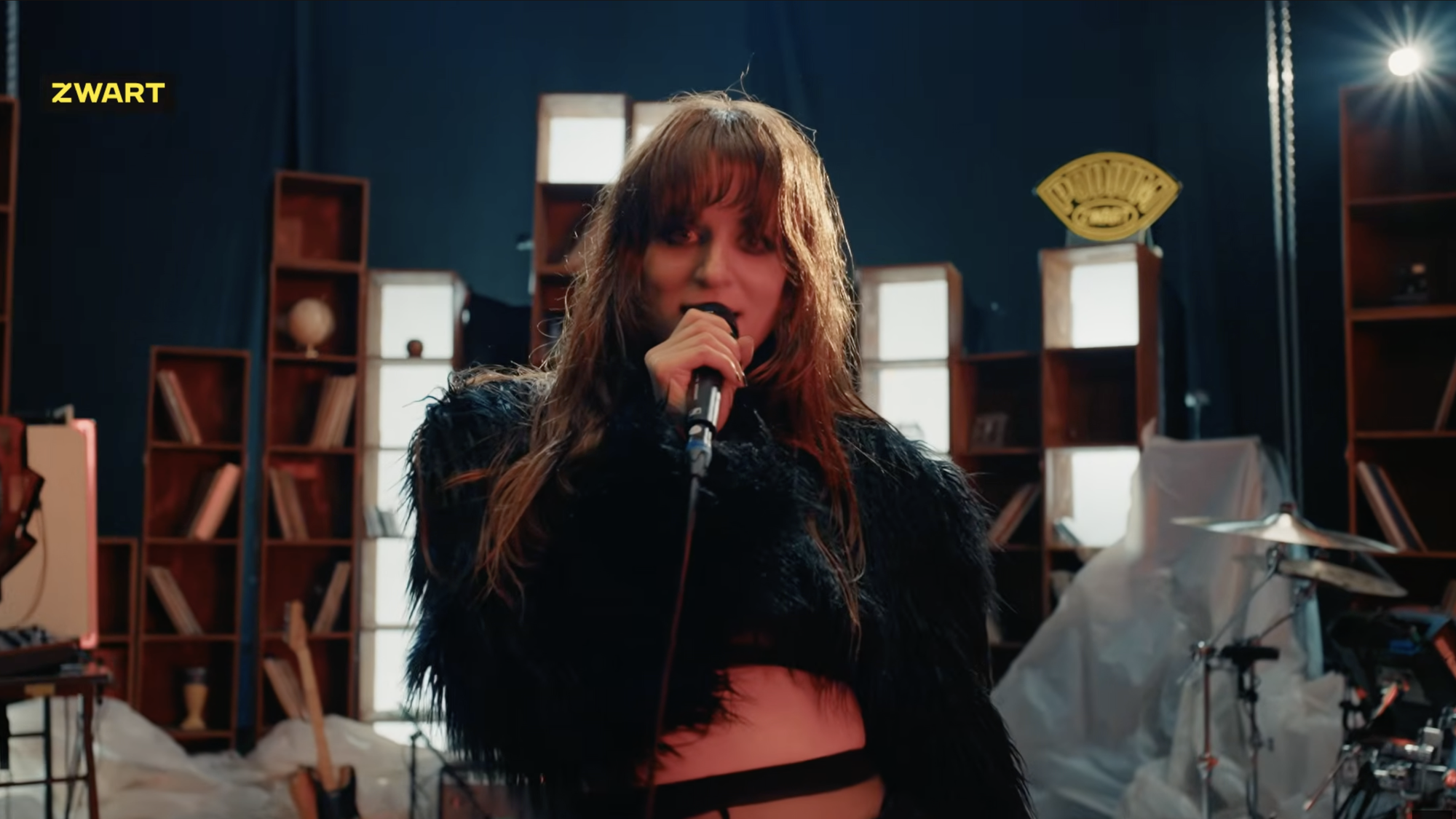 Zangeres MEROL staat te zingen in een zwart harige outfit