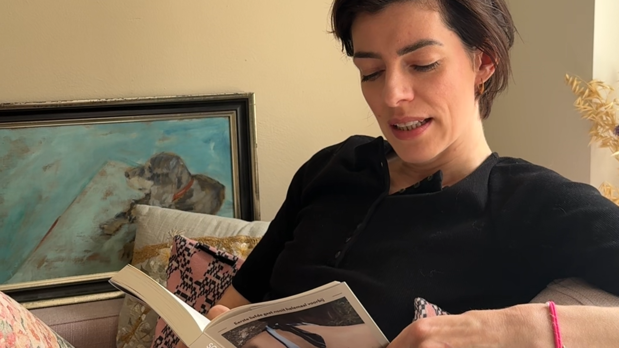 Sophie de schrijfster zit op de bank en leest voor.