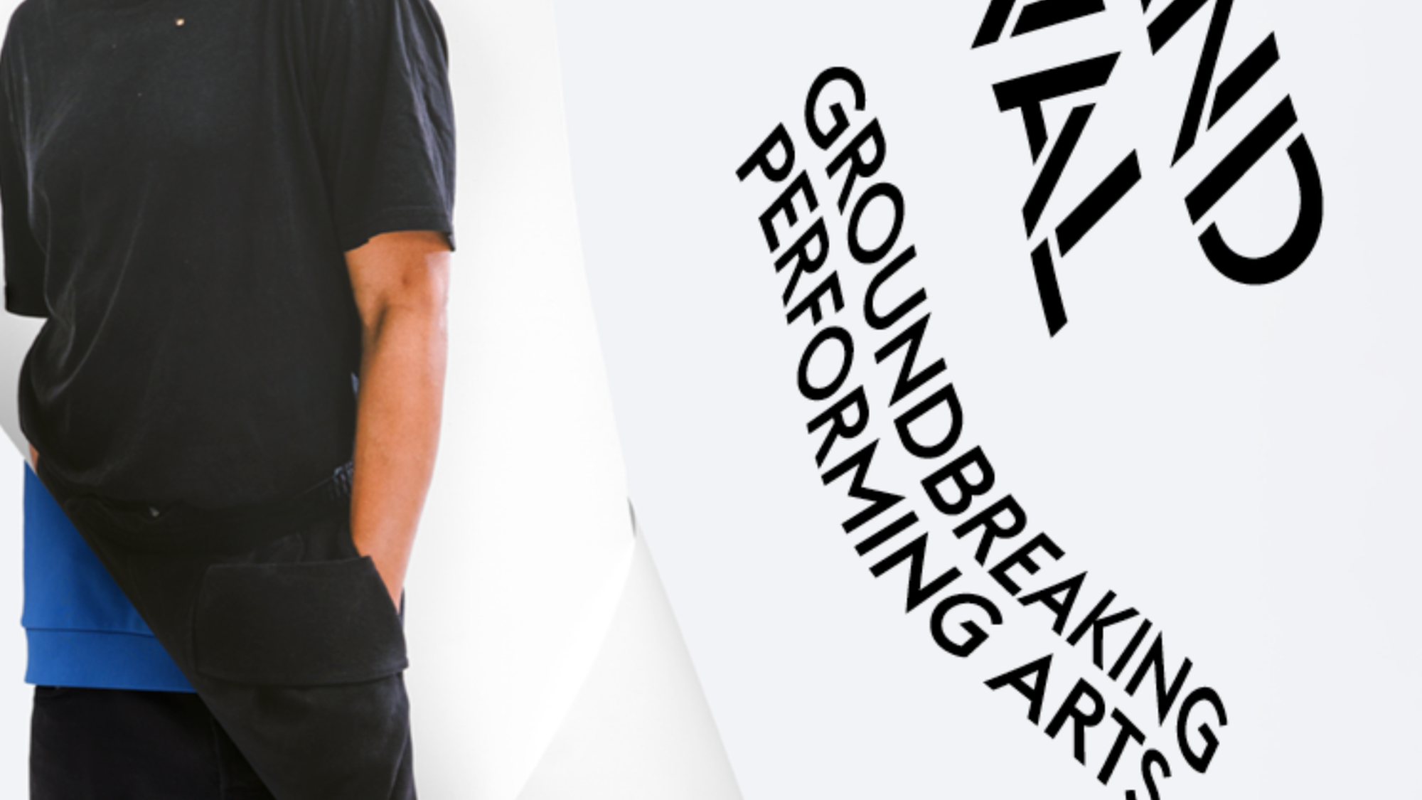 Een foto van Trajal Harell, de choreograaf. Je ziet hem ten voeten uit, met naast hem letters 'holland festival'. Hij staat voor een witte achtergrond en heeft zwarte kleding aan.