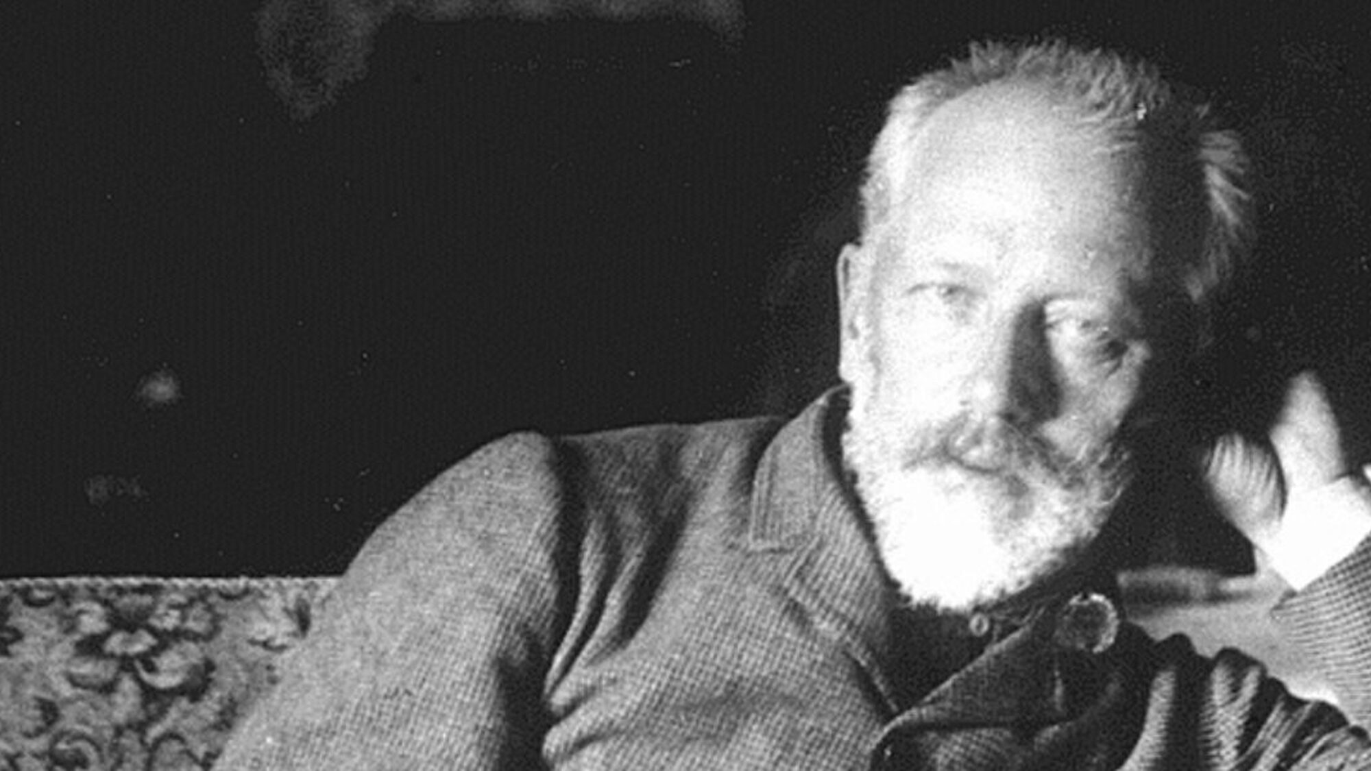 Zwart wit foto met witte russische man die componist is en liggend op een bank naar de camera kijkt