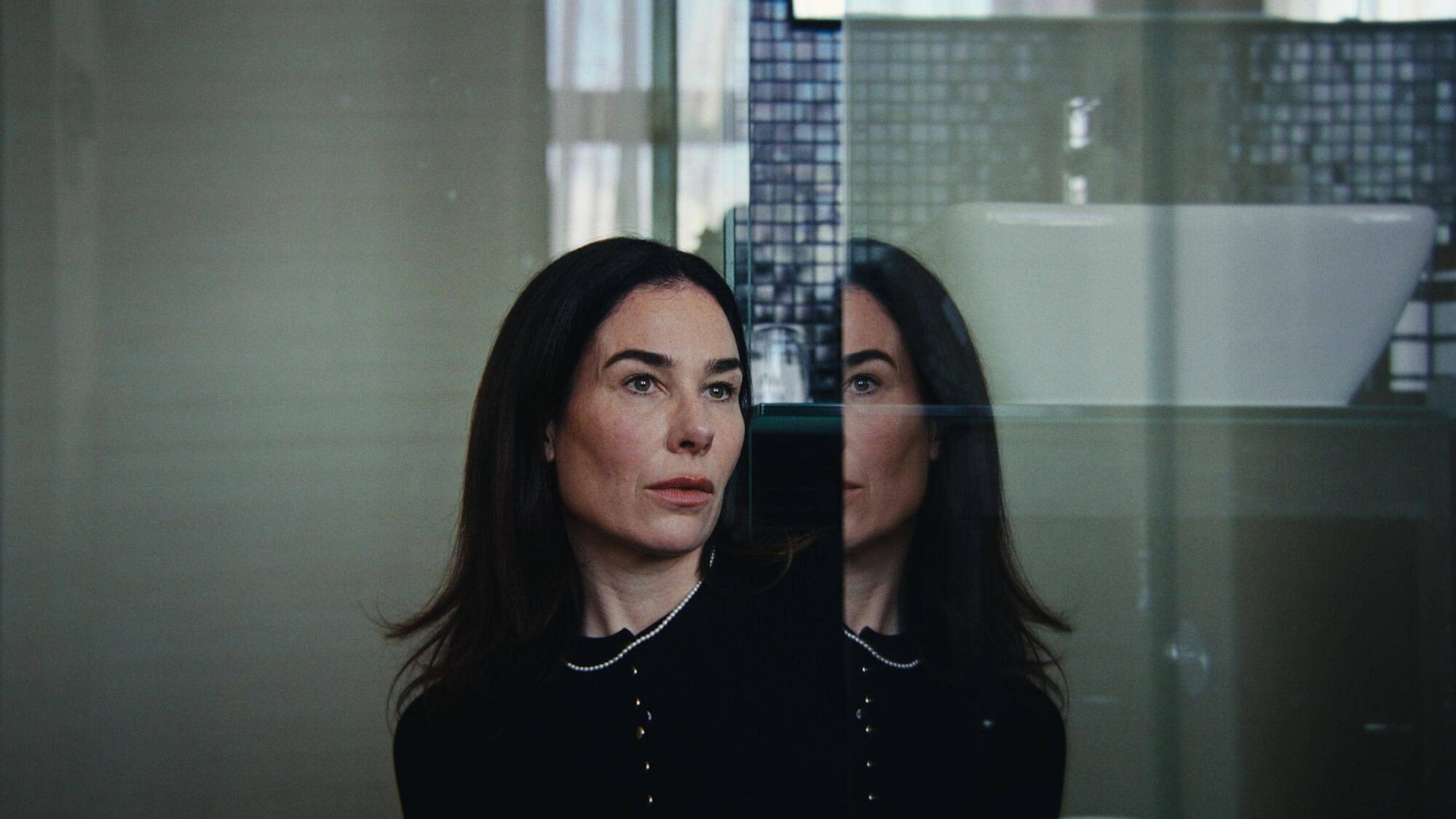 witte vrouw zit in een badkamer met een verbaasde blik