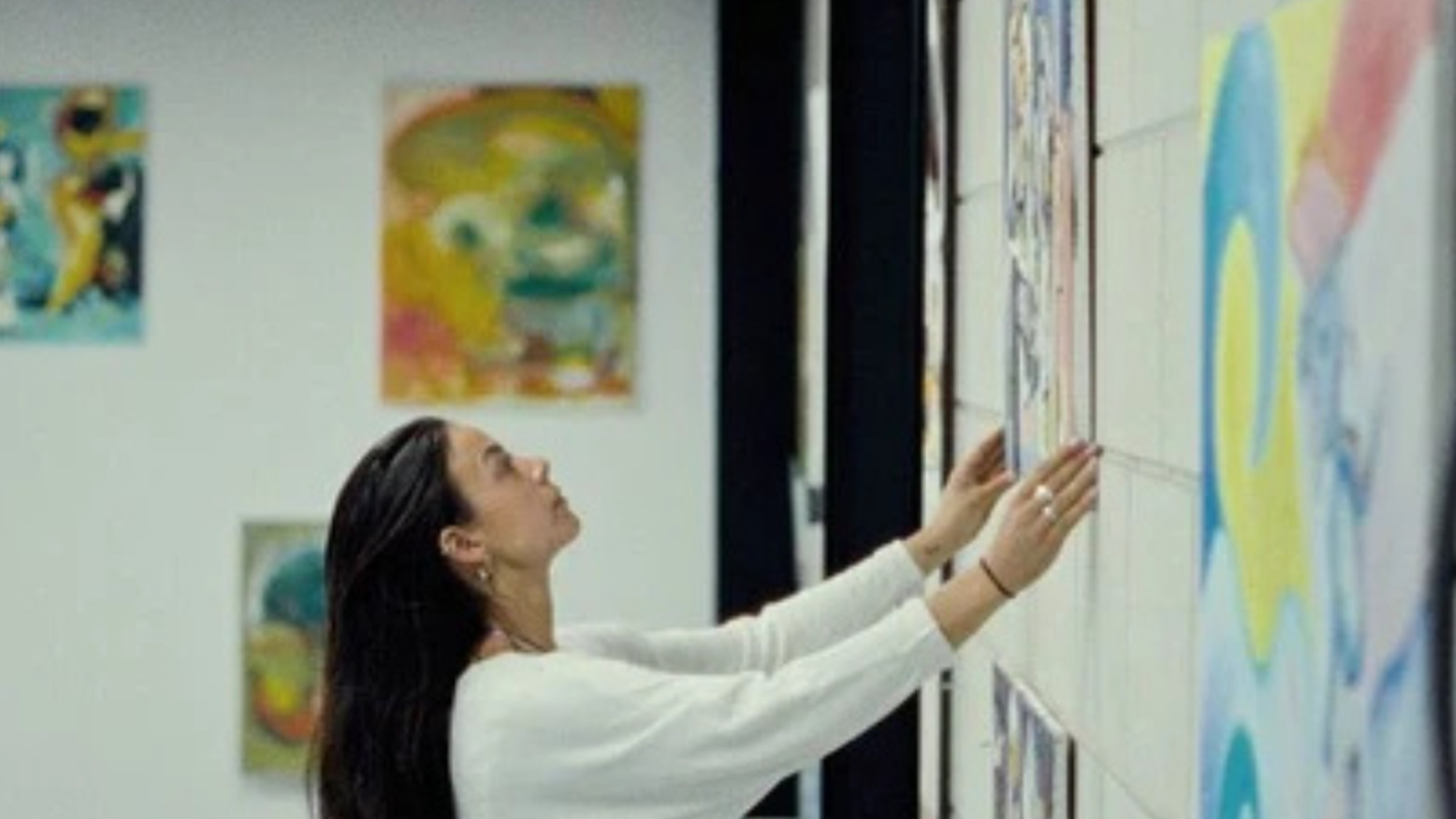 Vrouw hangt schilderij op in loods