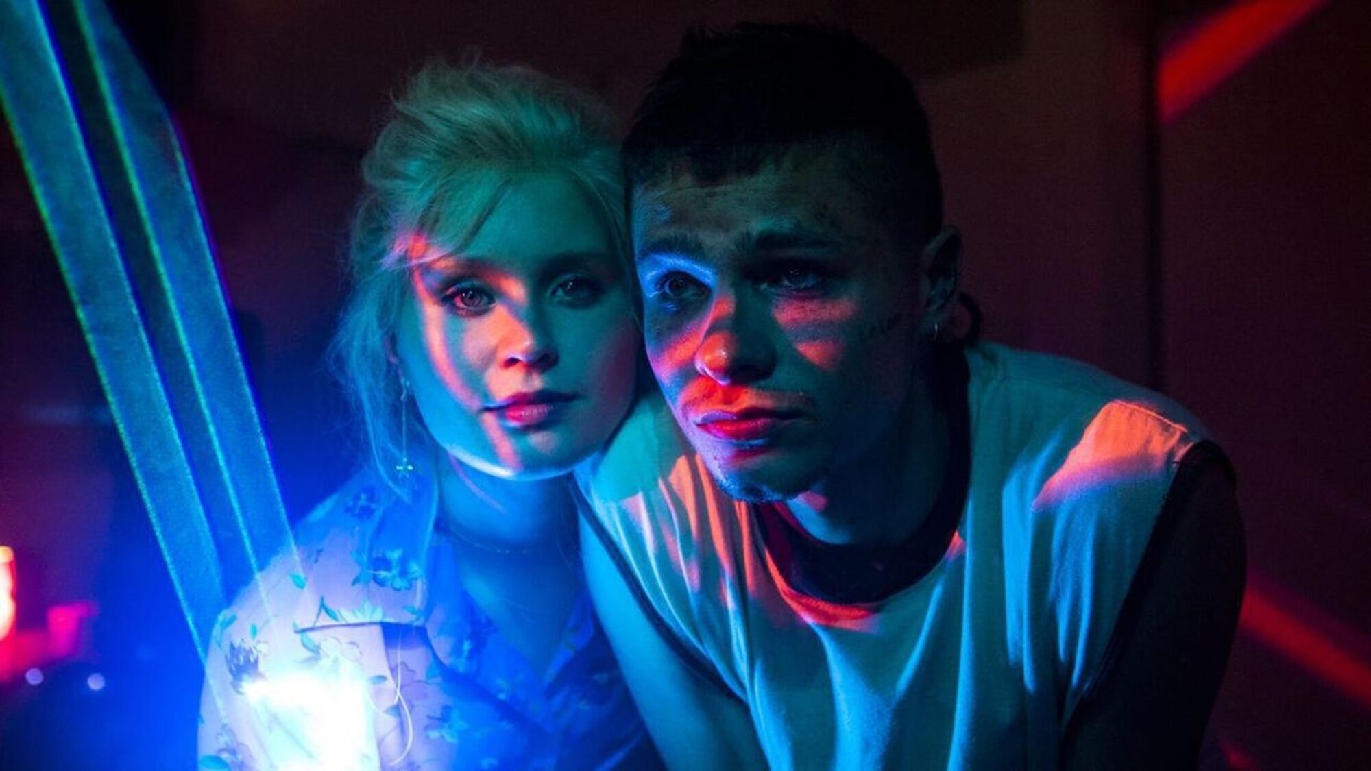 Een meisje en een jongen in een club, het licht schijnt op hun gezichten