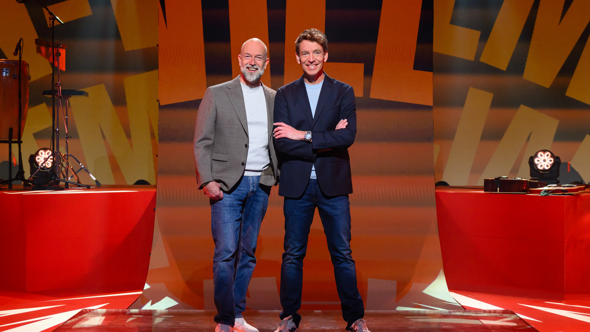 Twee mannen staan samen blij in de studio