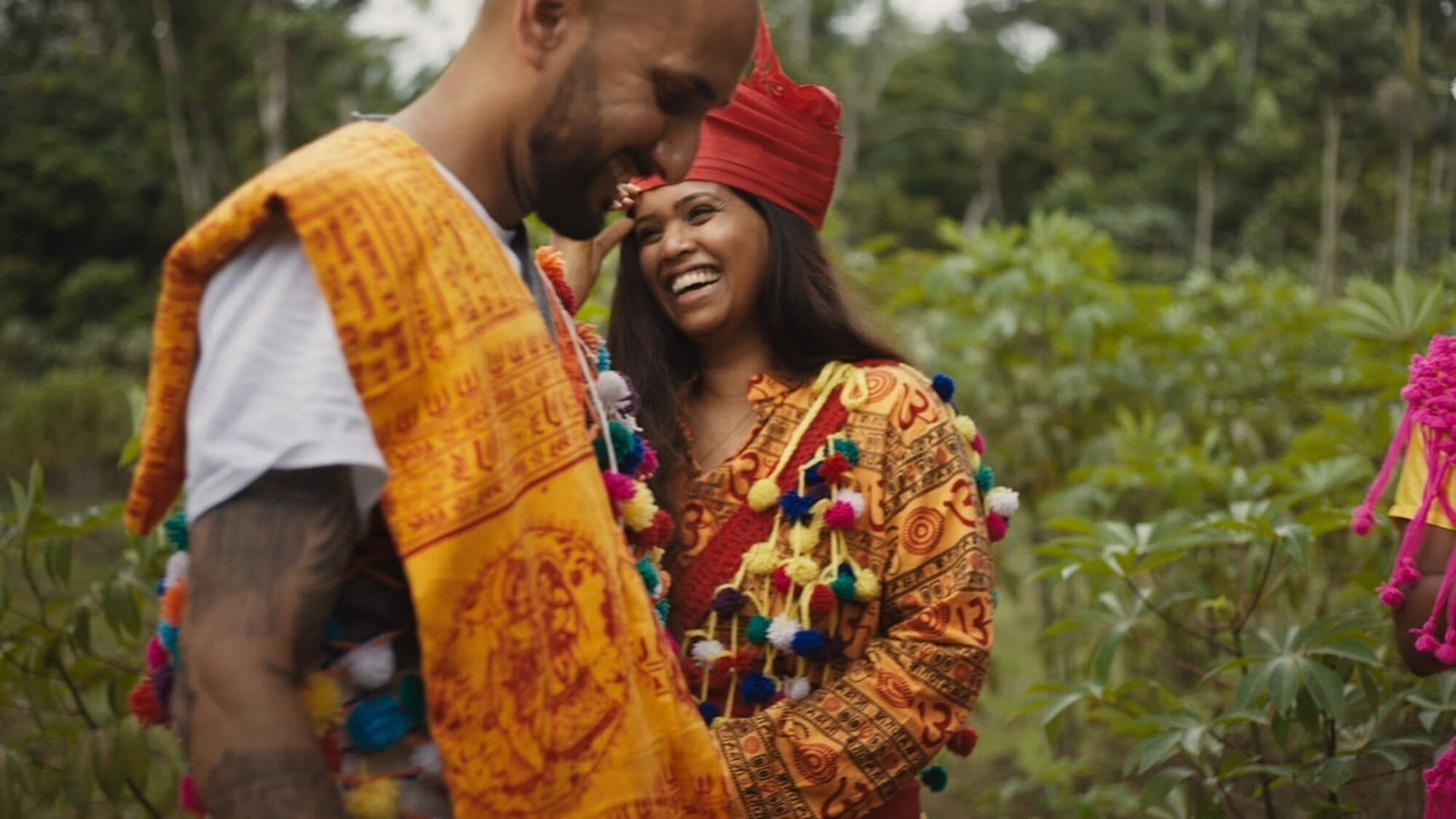 Een man en een vrouw lachen samen. Ze staan in een achtergrond met natuur.