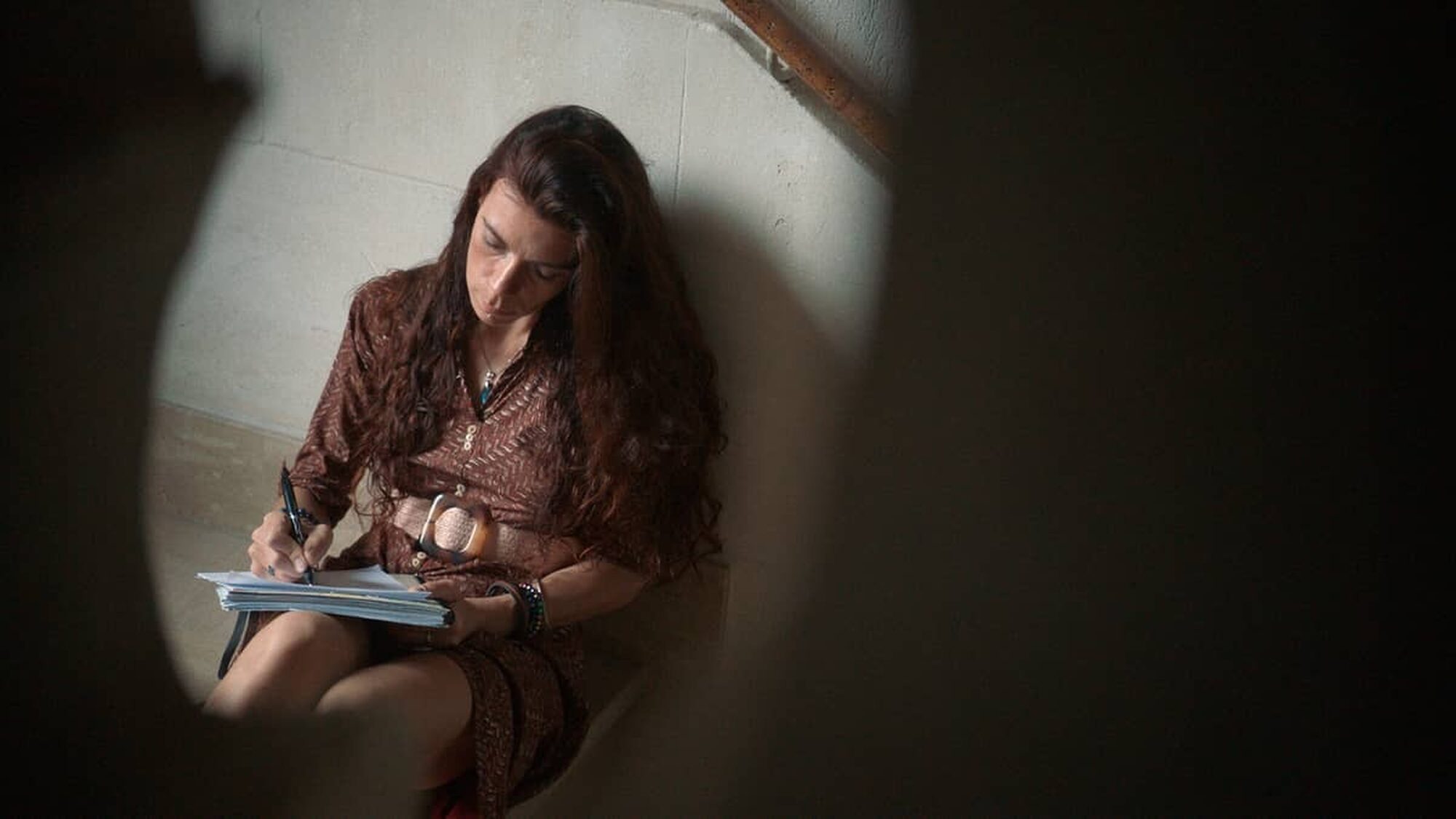 Vrouw zit op een trap te schrijven