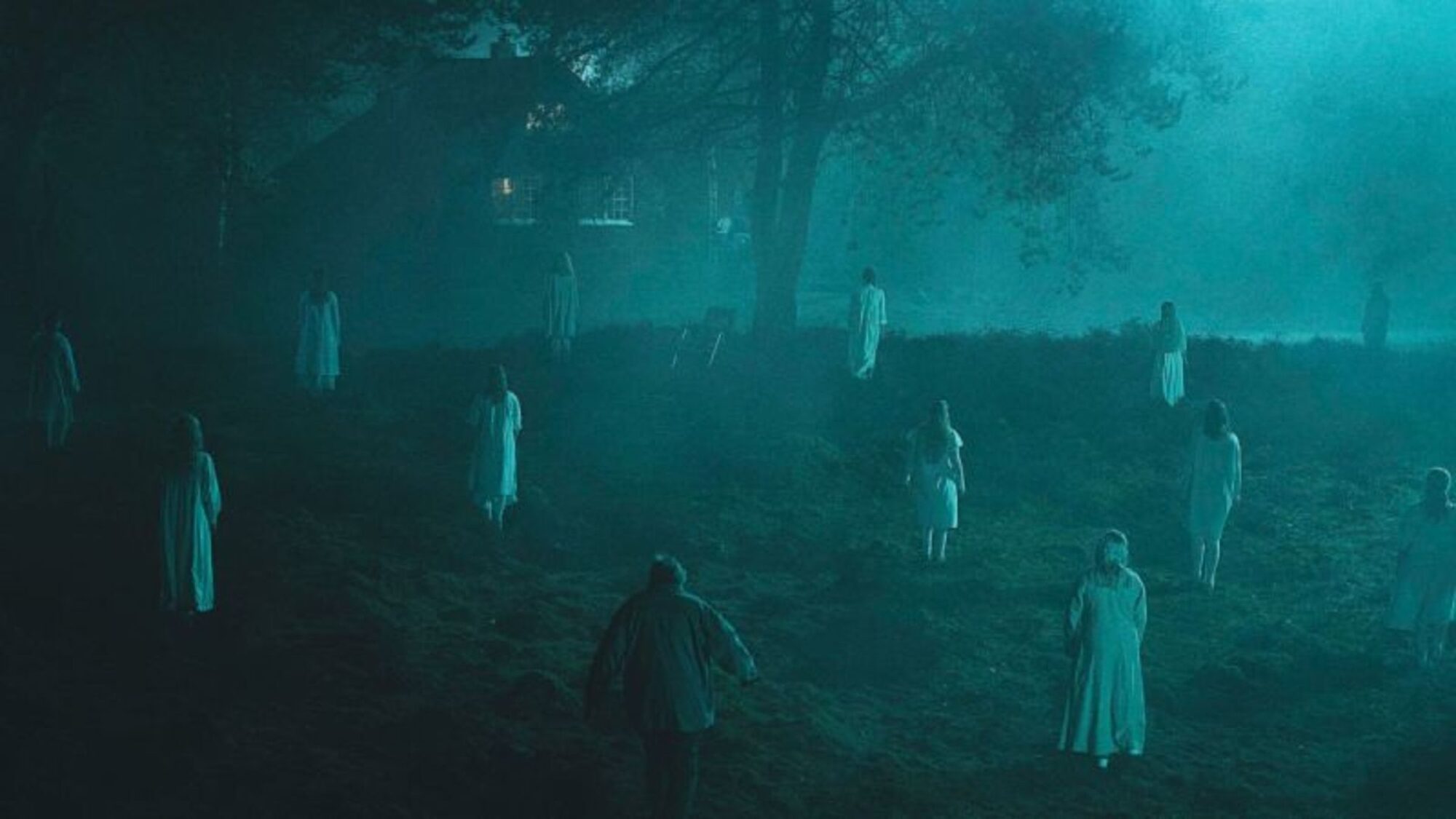 Vrouwen in witte gewaden staan in een veld, een man loopt op ze af