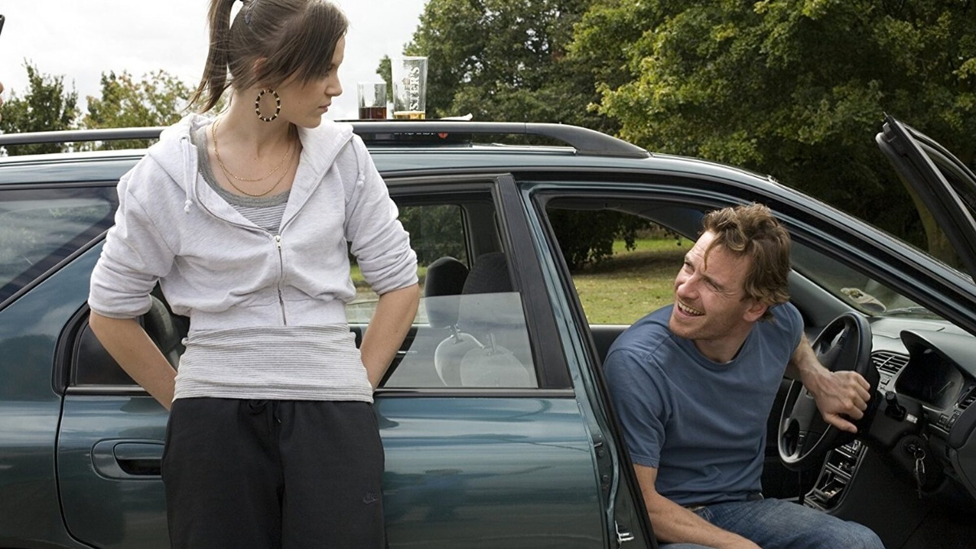 Een meisje kijkt naar naar een man die in een auto zit