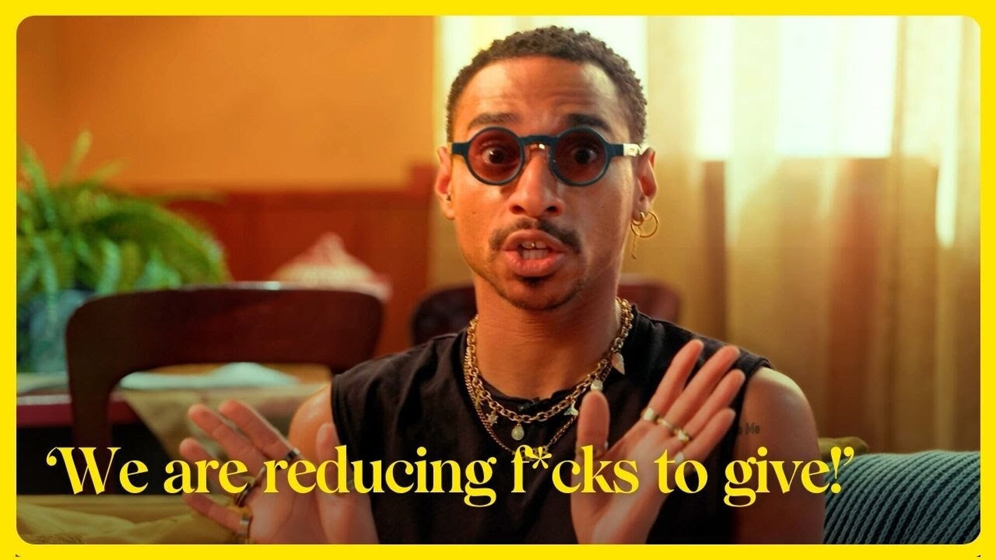 Man met ronde zonnebril kijkt de camera in, eronder staat de tekst: 'We are reducing f*cks to give!'