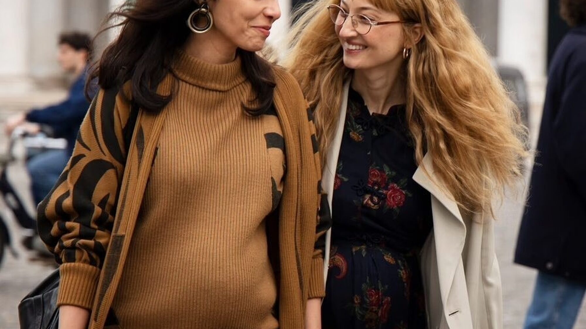 De vriendinnen lopen lachend over straat.