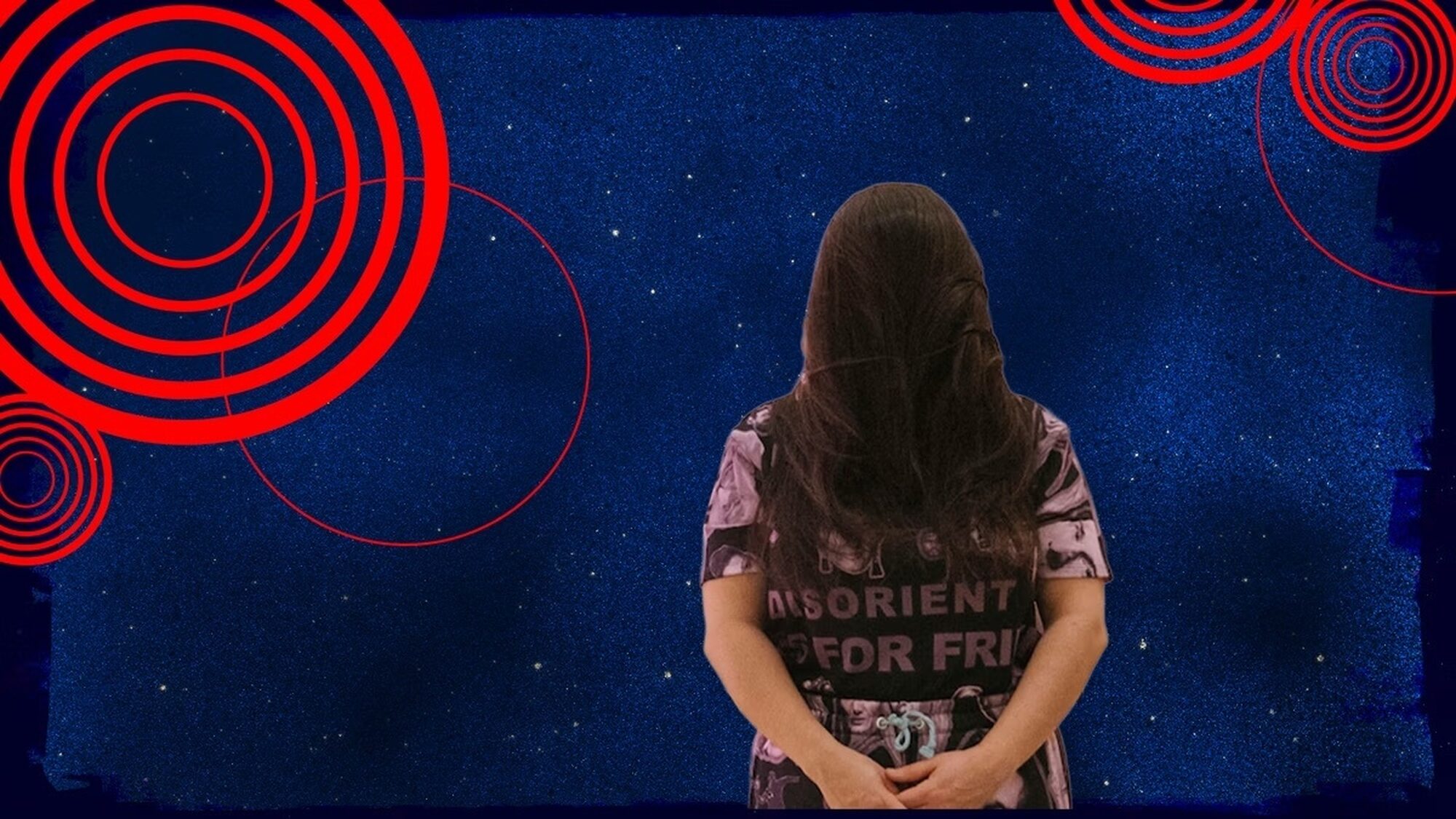 Susanne khalil yusef staat tegen een blauwe achtergrond, met haar handen op haar rug.