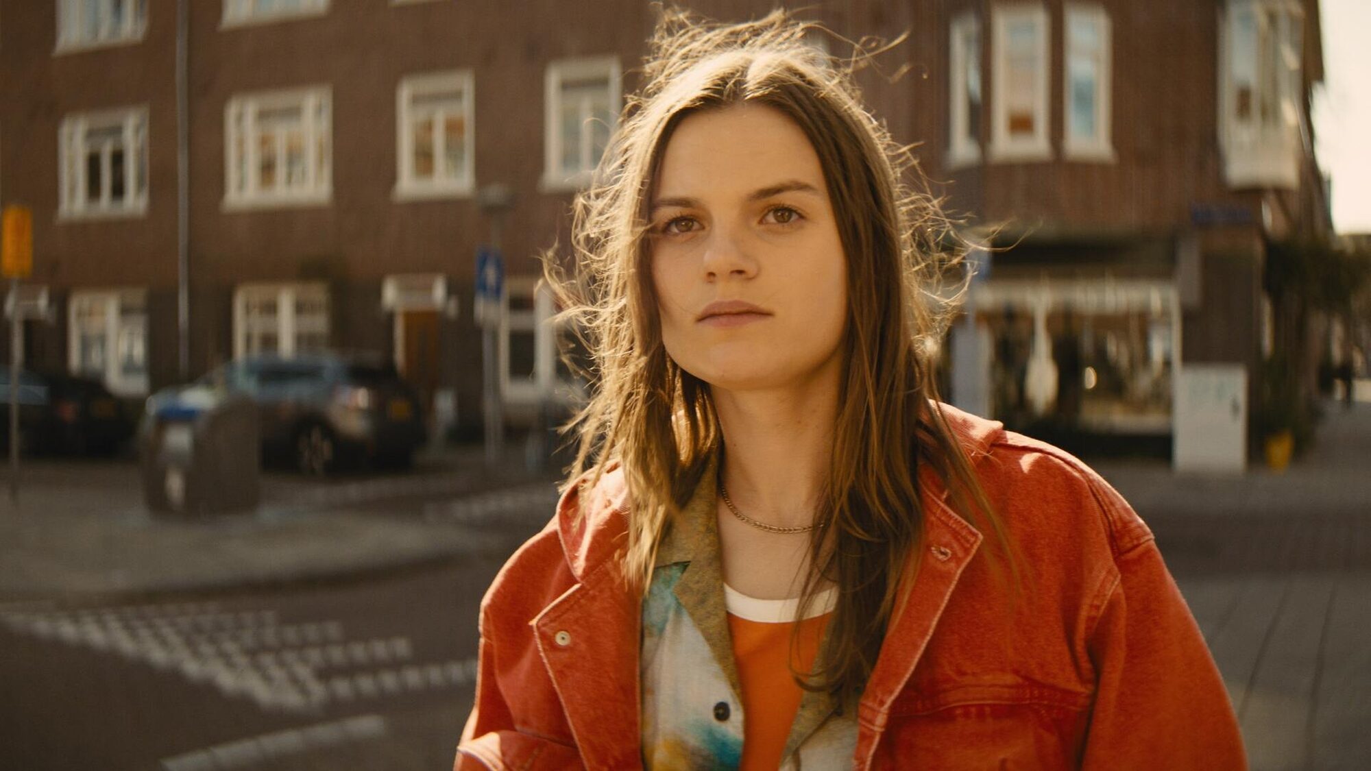 Bobje staat op straat in Amsterdam en kijkt naar iets buiten beeld