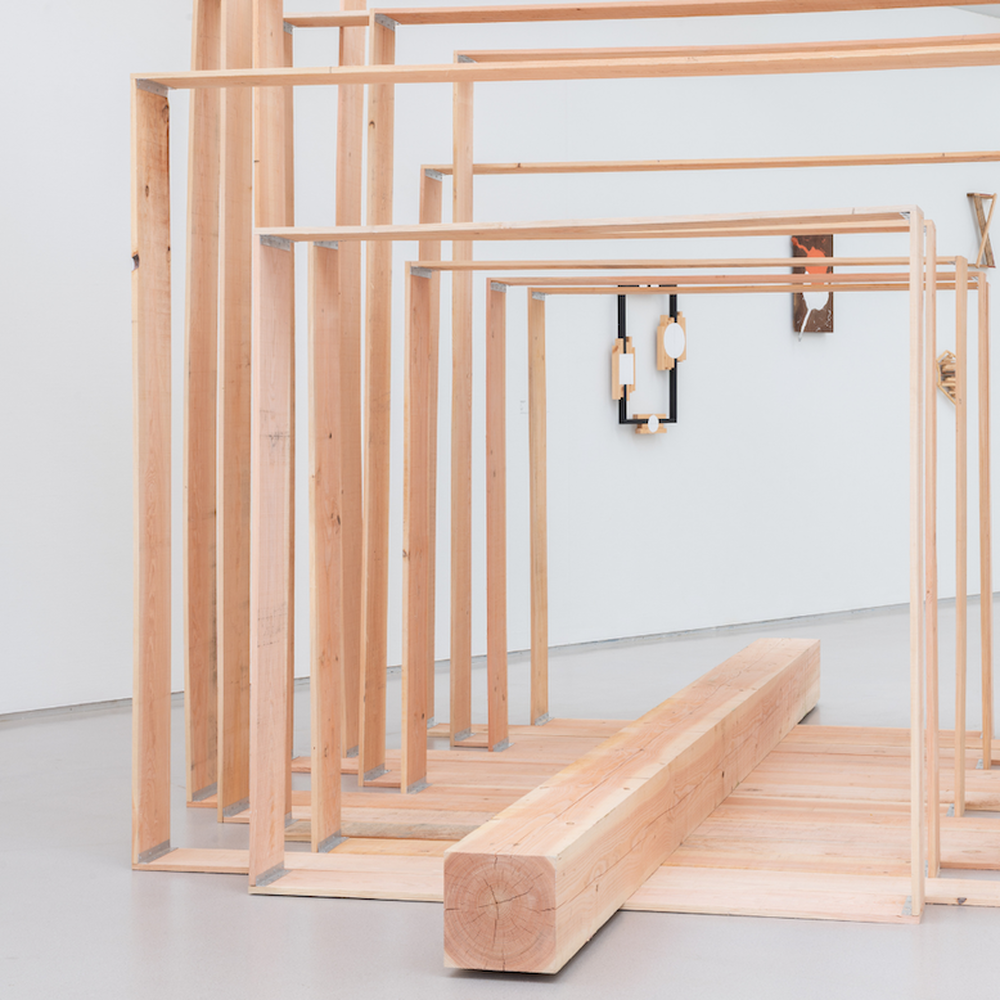 Kunstwerk van Kishio Suga; houten frames met een houten balk in het midden.