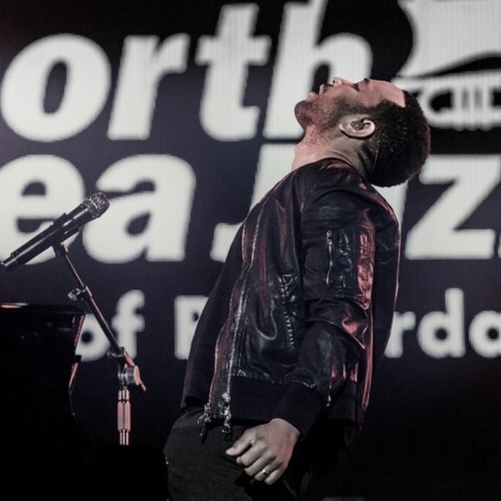 Zanger leunt tijdens het zingen naar achteren op het podium van het North Sea Jazz festival.