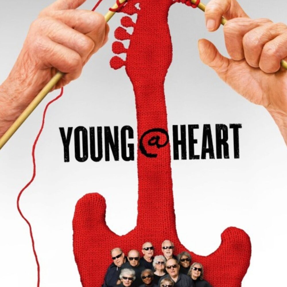Cover van de documentaire Young@heart. Twee handen breien een rode gitaar. Daaronder staan de koorleden.