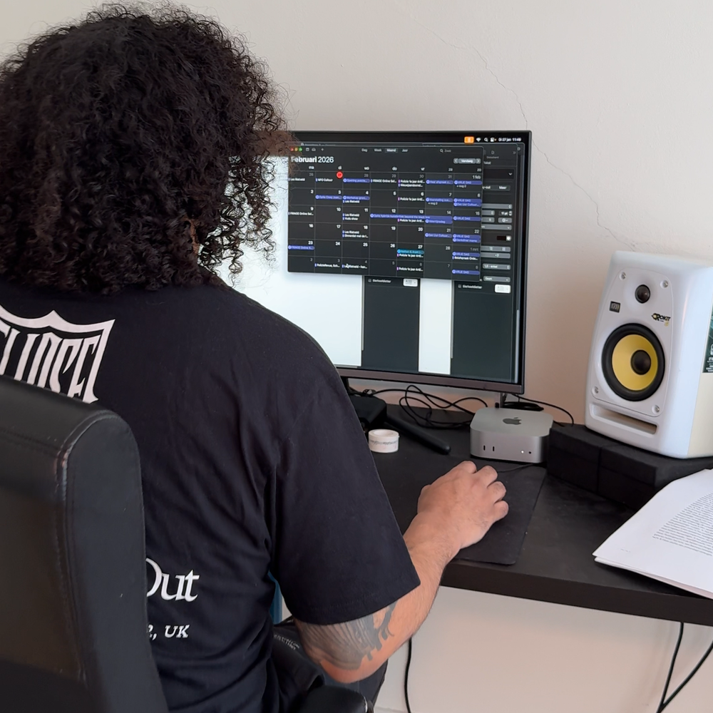 Een foto van Dean Bowen die achter zijn bureau zit. Je ziet hem op de rug en hij zit achter een computerscherm te werken.