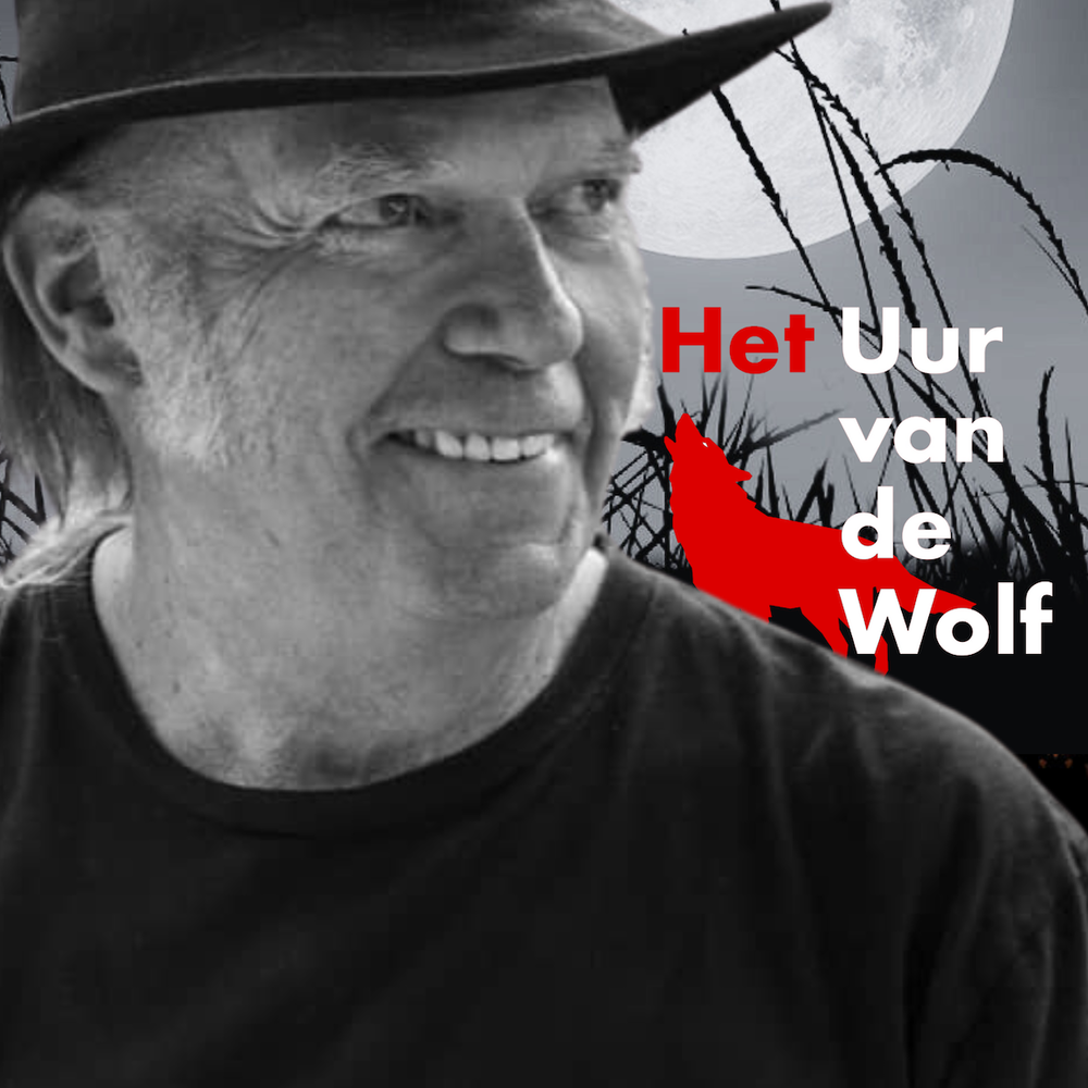 Neil Young kijkt lachend opzij en draagt een hoed.