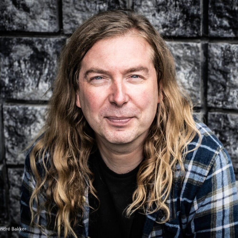 Luuk Bouwman kijkt de camera in met zwarte tegels op de achtergrond