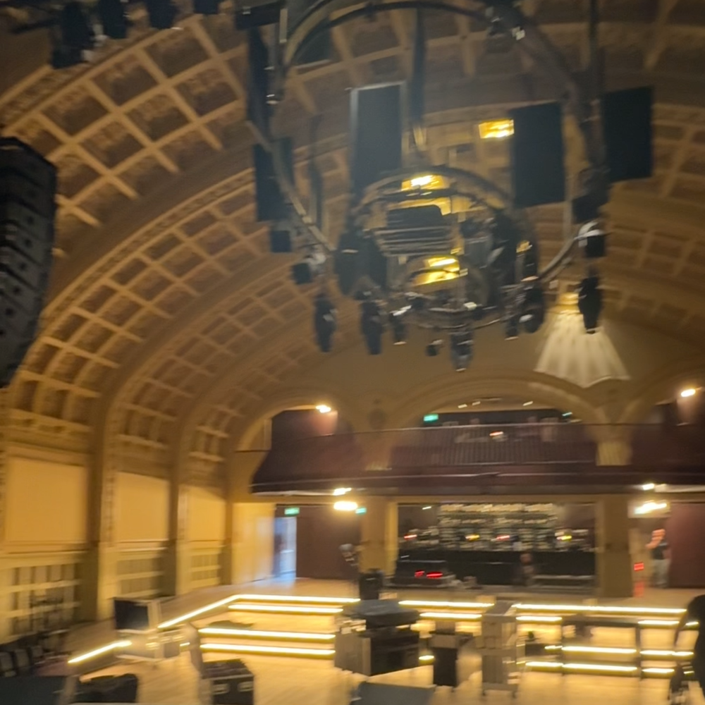 Een foto van de zaal Luxor Live. Een hele statige zaal, met kleine lampjes in het plafond.