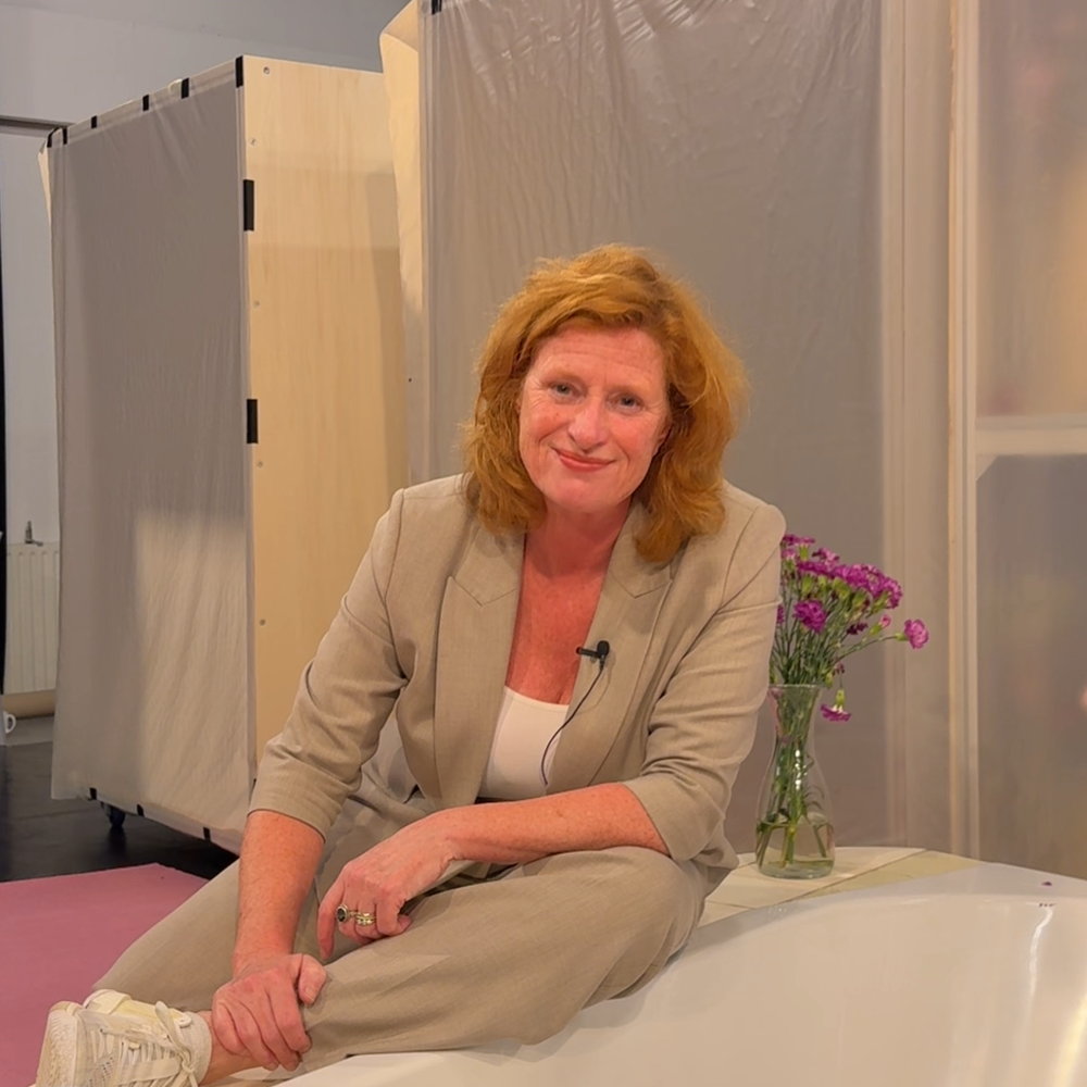 Hier zien we Oda, de actrice waar dit artikel over gaat in het decor zitten. Ze lacht vriendelijk naar de camera en zit op een badrand.