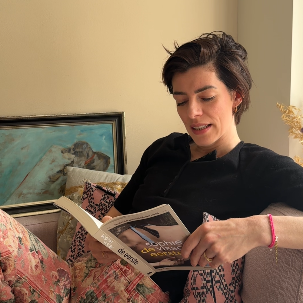 Sophie de schrijfster zit op de bank en leest voor.