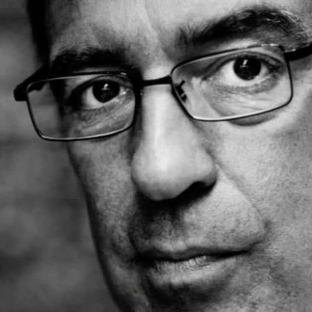 Joost Zwagerman met een bril op kijkt de camera in