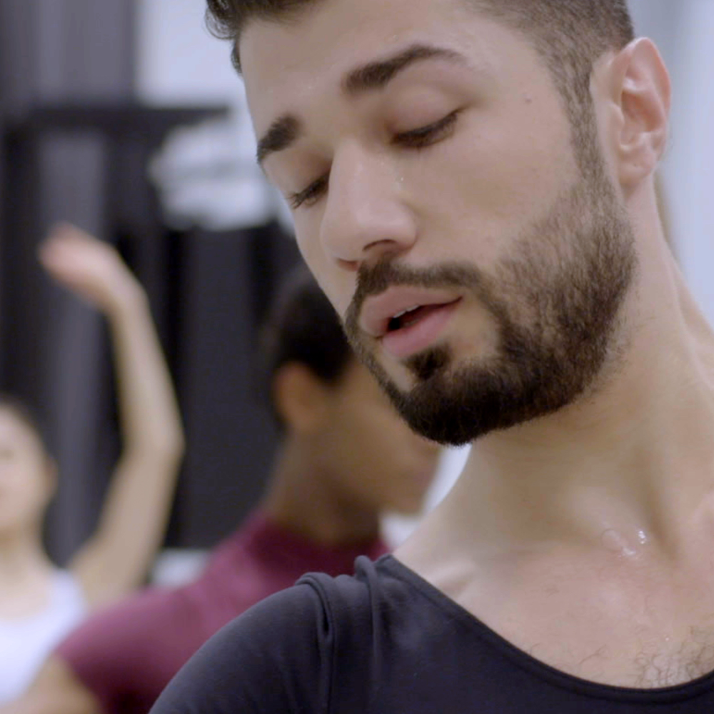 Een stil van de dansende Ahmad, waar deze documentaire over gaat. Hij heeft een zwart shirt aan en je ziet hem van zijn schouders tot zijn kruin. Hij heeft zijn ogen dicht, donker haar en een donkere baard en snor.