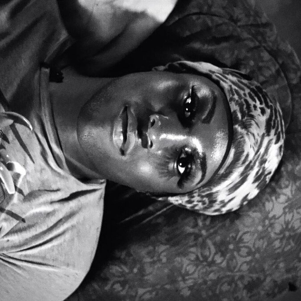 Een van de hoofdpersonen ligt op bed en kijkt verdrietig voor zich uit.