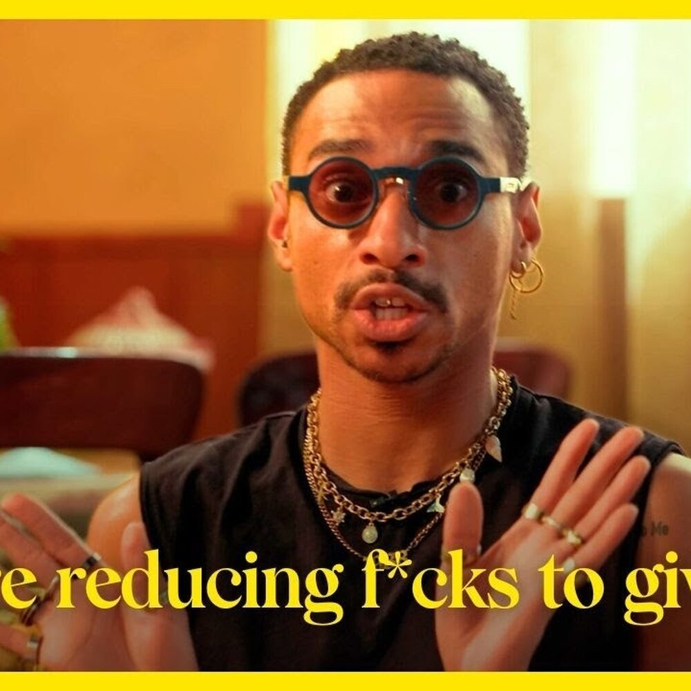 Man met ronde zonnebril kijkt de camera in, eronder staat de tekst: 'We are reducing f*cks to give!'