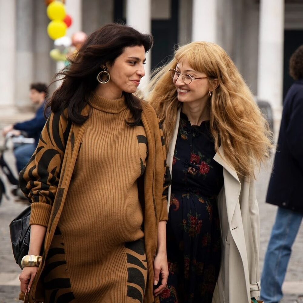 De vriendinnen lopen lachend over straat.