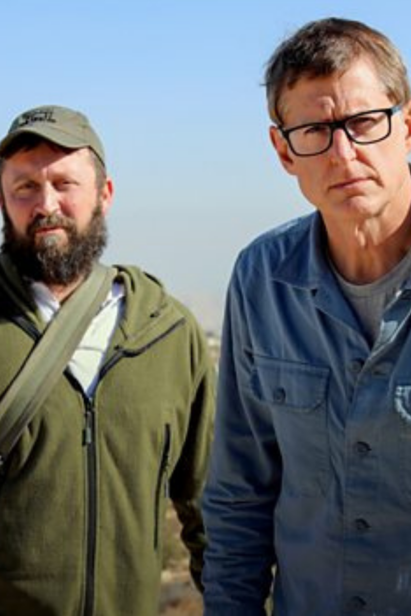 Louis Theroux met een man in een groene trui.