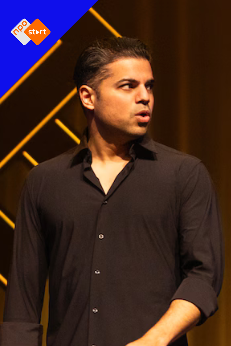 Cabaretier met zwart overhemd staat in actie op het podium