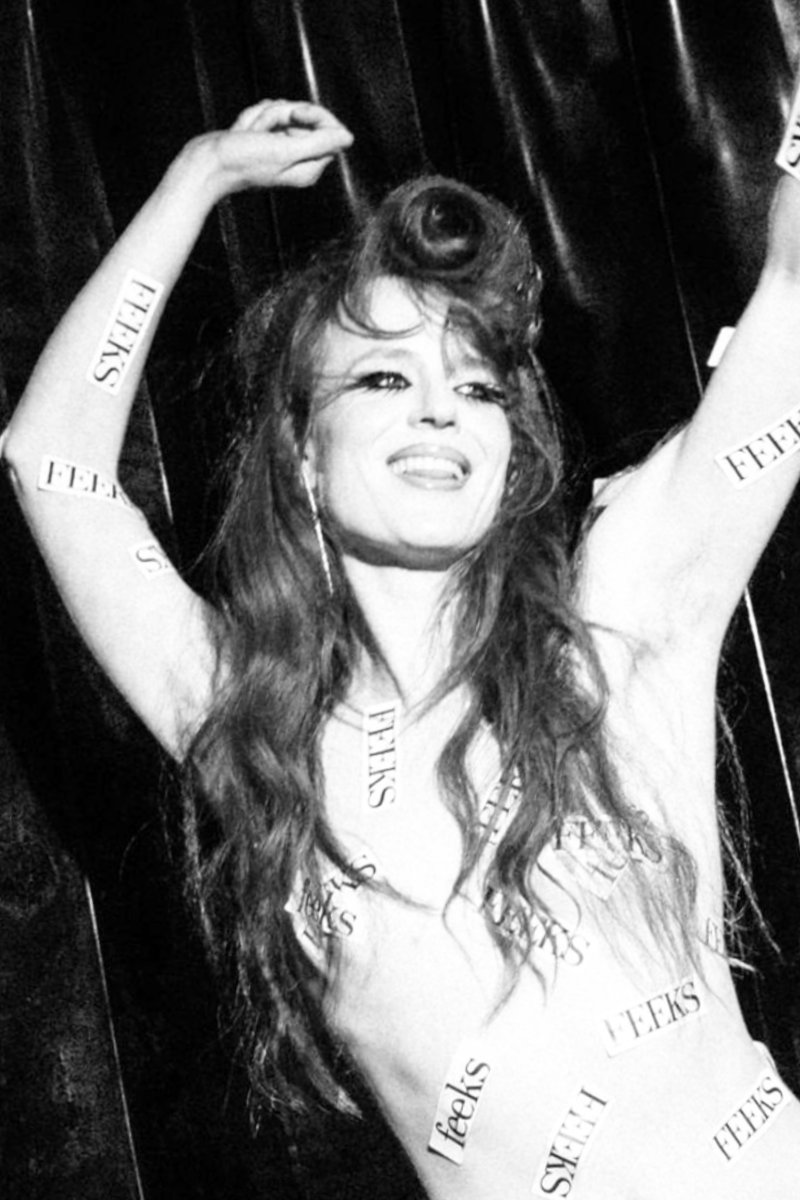 Witte vrouw staat beplakt met feeks stickers op haar lichaam dansend in zwart en wit