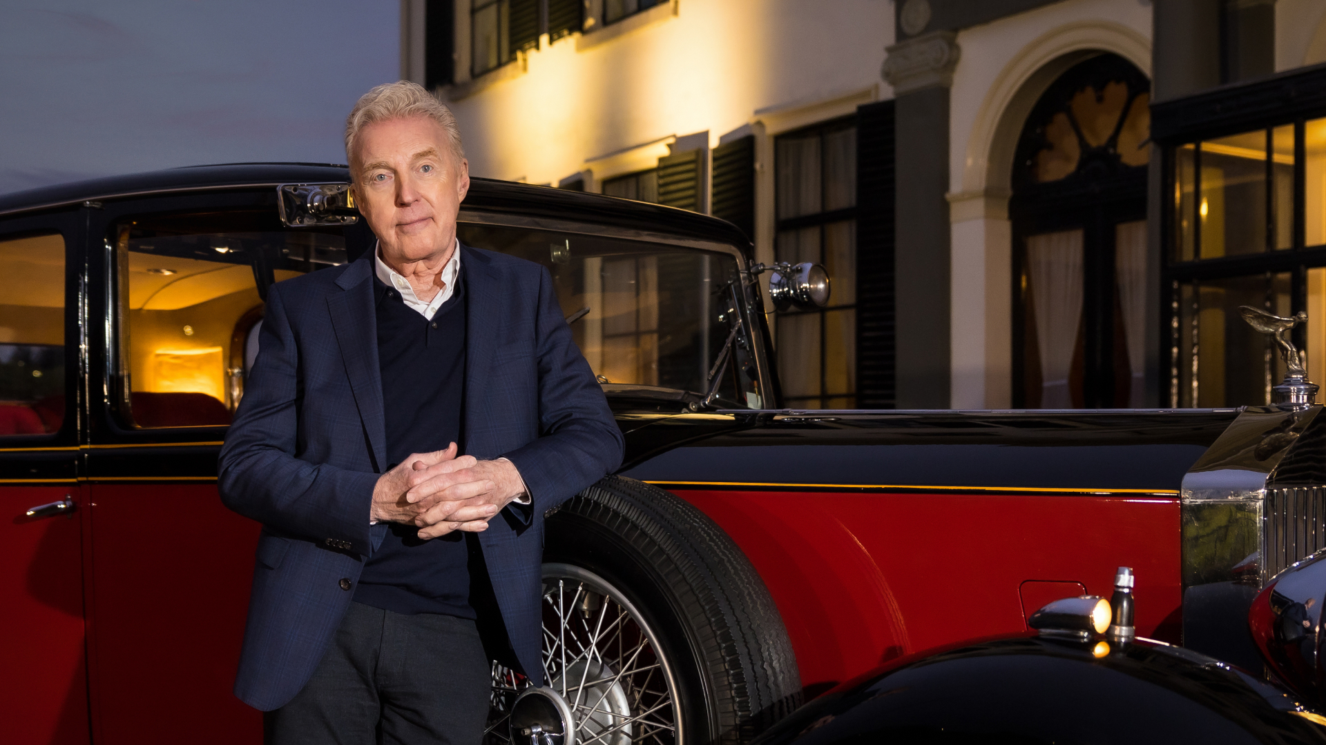 André van Duin voor een oude oldtimer