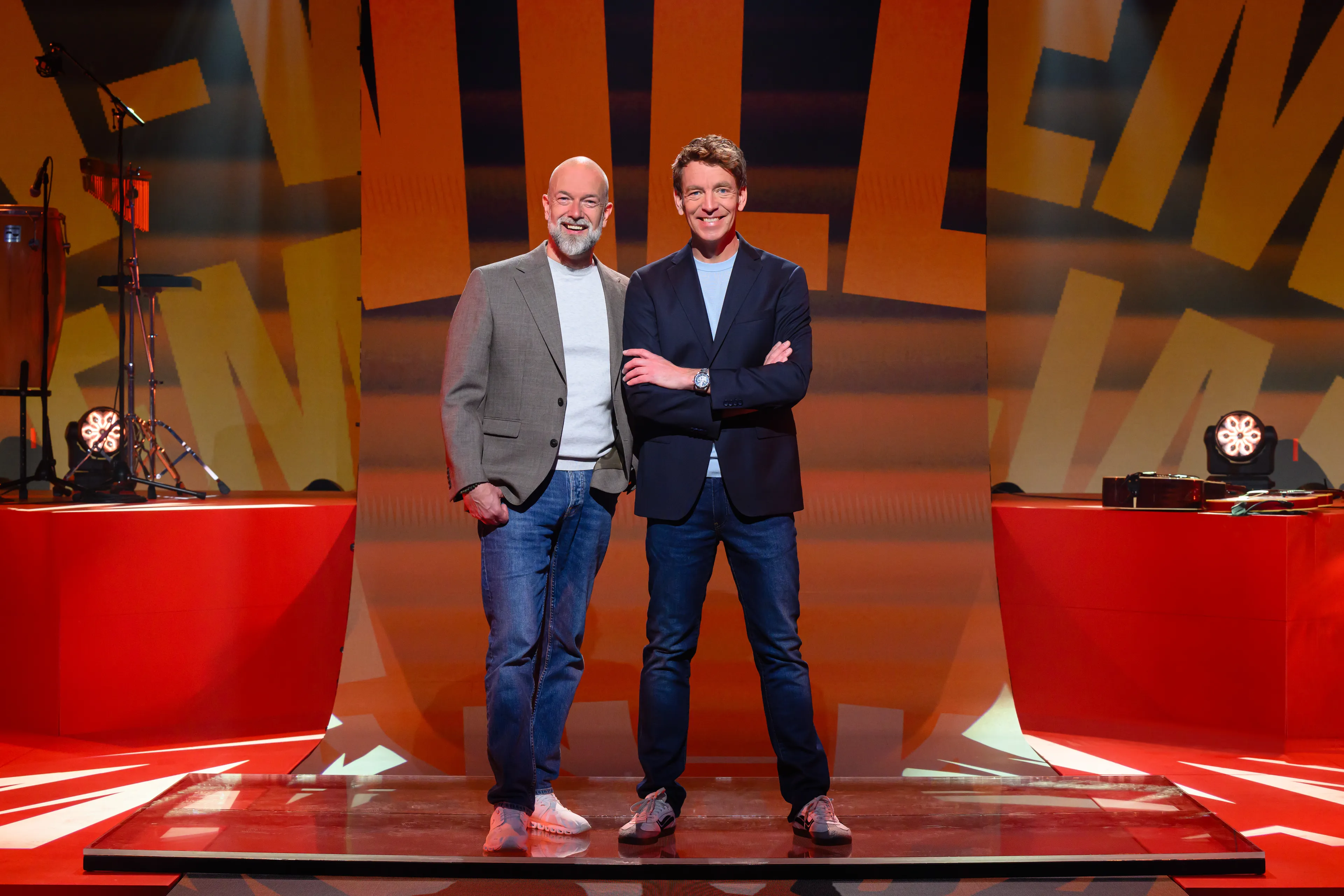 Twee mannen staan samen blij in de studio