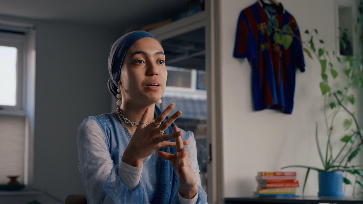 Meisje met een lichtblauwe hoofddoek verteld in close up
