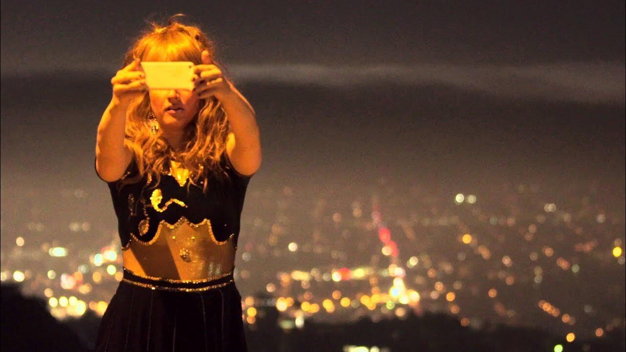 Vrouw neemt een selfie vanaf grote hoogte met een stedelijke achtergrond